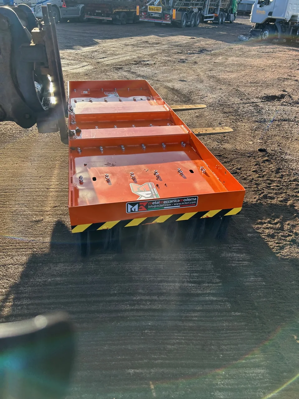 Orange M3-sopborste på maskinens gafflar hos Åkerbloms i Hedemora